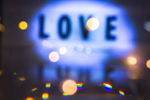 Free Blurred abstract bokeh image featuring the word 'Love' in bright lights. Stock Photo
