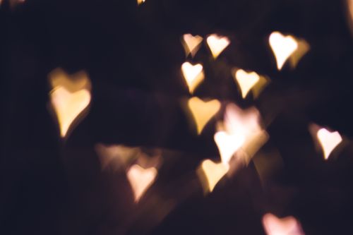 Free Blurry heart-shaped bokeh lights creating a warm and romantic atmosphere. Stock Photo
