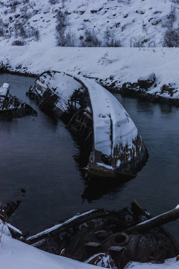 A Sinking Snow Covered Boat On A Lake