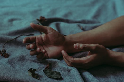 特写镜头中，双手放在铺满干树叶的毯子上，营造出忧郁的氛围