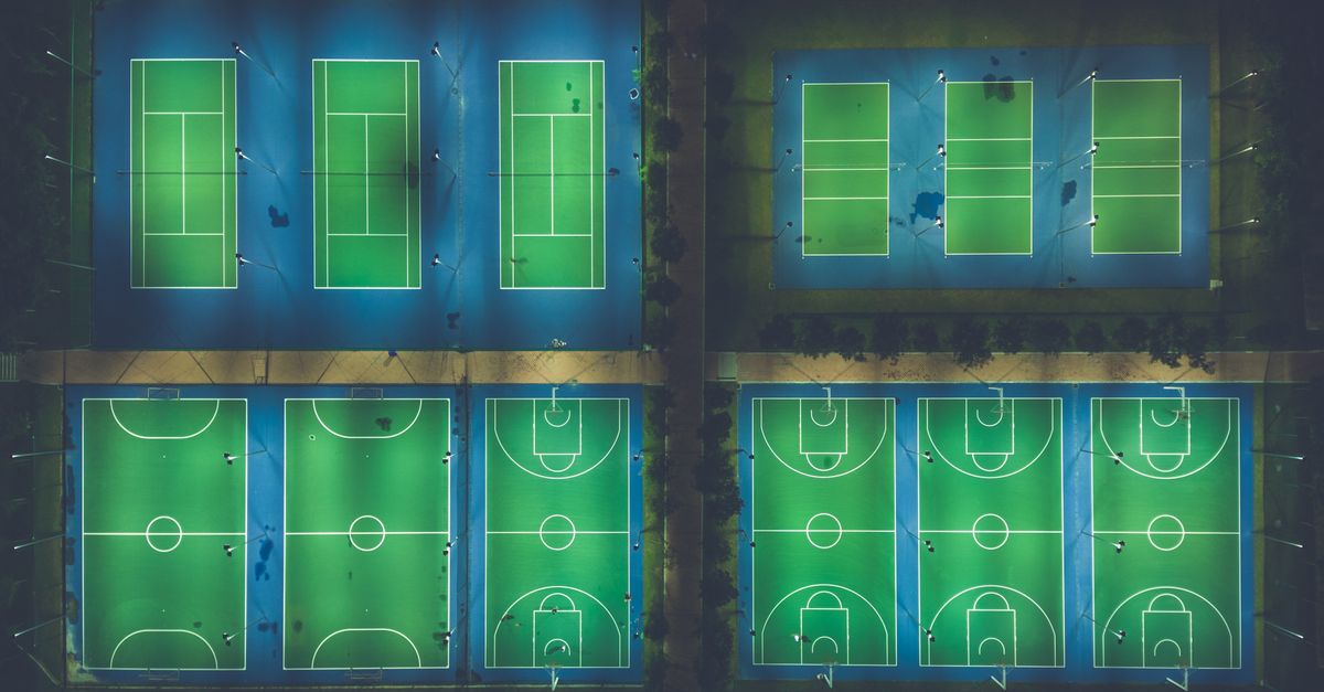 Empty basketball court at night with streetlights