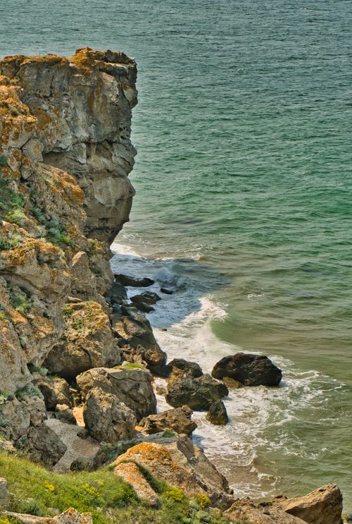 Free Stunning coastal cliff face with waves crashing against rocks, perfect for seascape lovers. Stock Photo