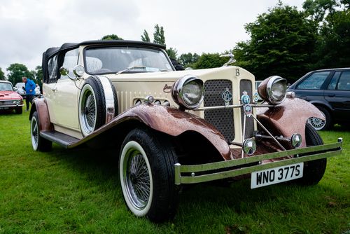 Free Vintage Beauford parked on a grass field with raindrops, exuding timeless elegance. Stock Photo