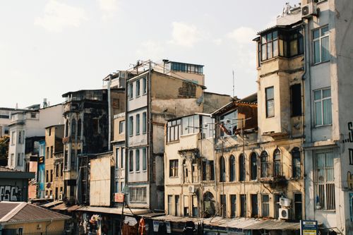 Free A row of aged urban buildings showcasing architectural heritage under bright sunlight. Stock Photo