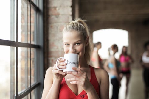 Free Woman in Red Scoop-neck Tank Top Holding White Mug Stock Photo