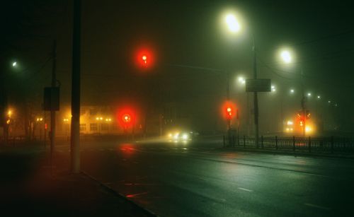 Free A foggy nighttime city intersection in Moscow with glowing street and traffic lights casting an eerie ambiance. Stock Photo