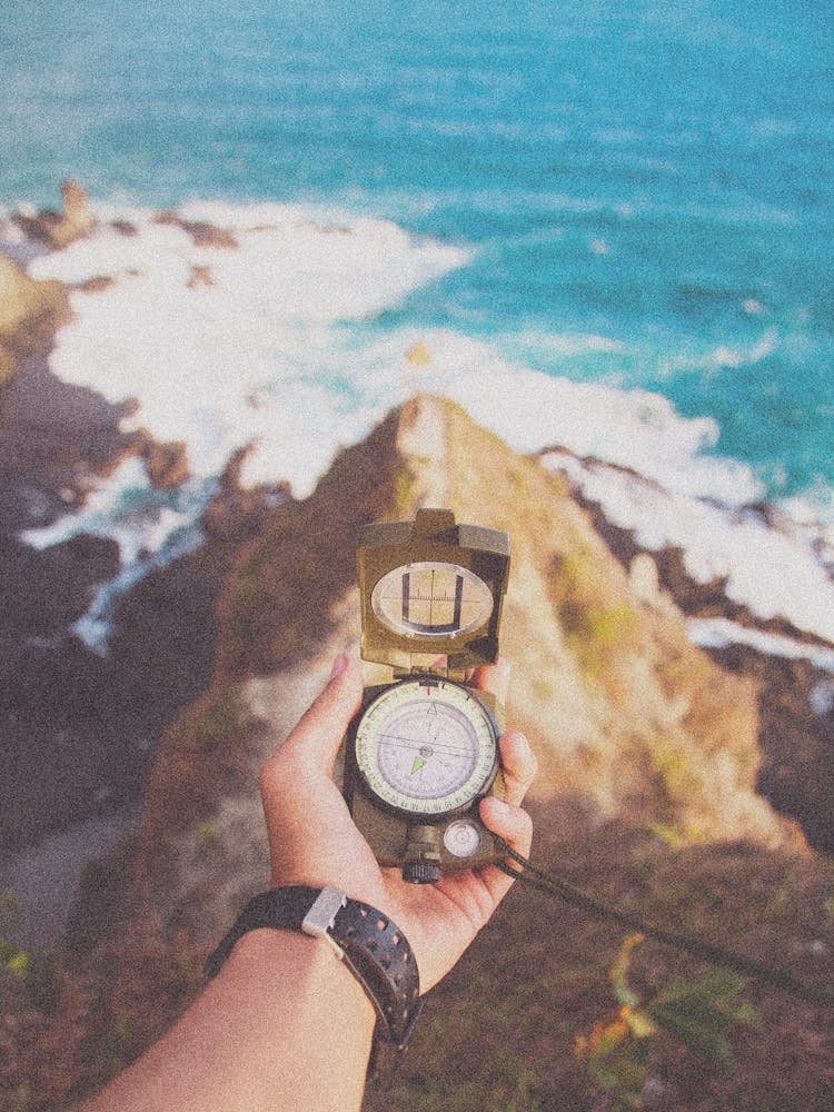 A Person Holding A Compass