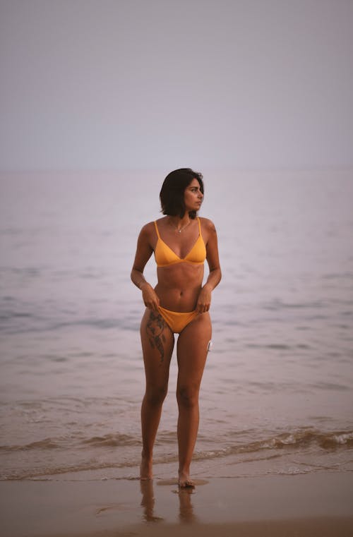 Woman in Brown Bikini Standing on Beach