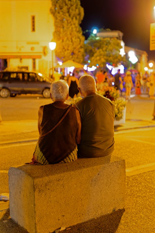 A Couple Sitting on Concrete Bench
