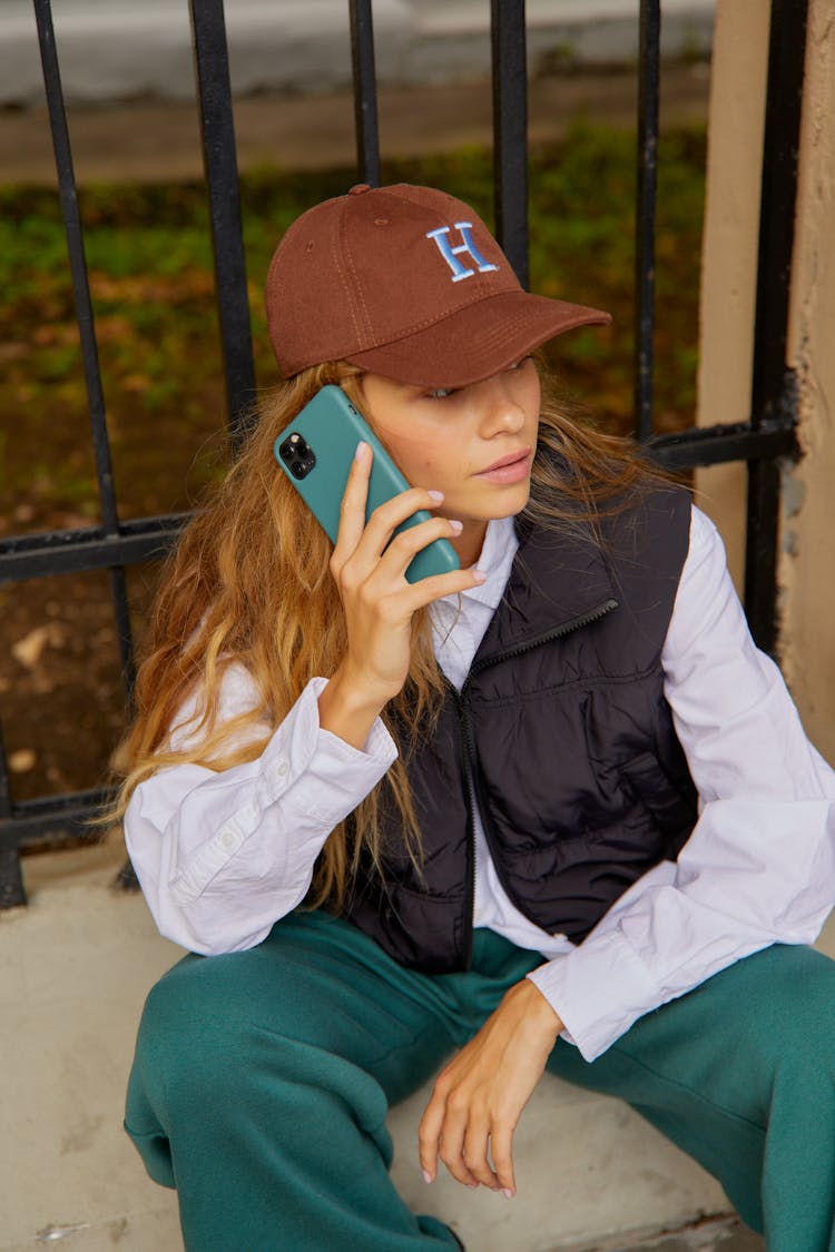 Woman In Black Vest Talking On The Phone