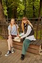 College Students Sitting on a Wooden Bench