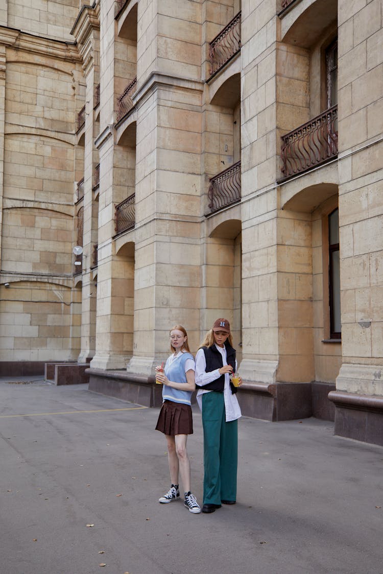 College Students Standing Outside A Building Holding Beverages