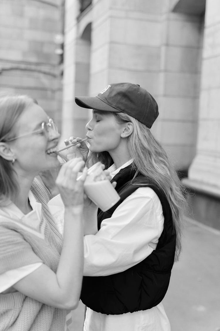 Grayscale Photo Of Girls Drinking Together