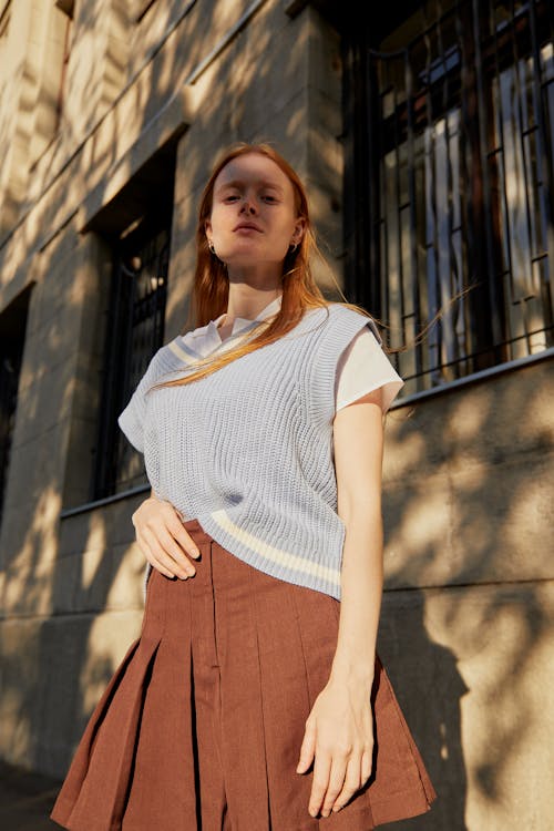 A Woman in Blue Vest and Brown Skirt