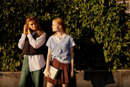 Free Two fashionable women outdoors, stylish and surrounded by greenery. Stock Photo