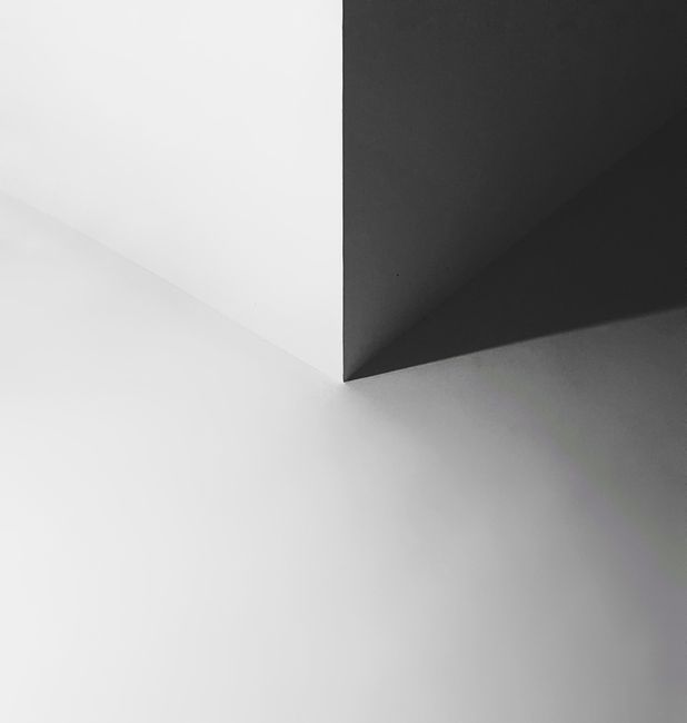 A striking minimalist geometric design with black and white shapes and shadows.