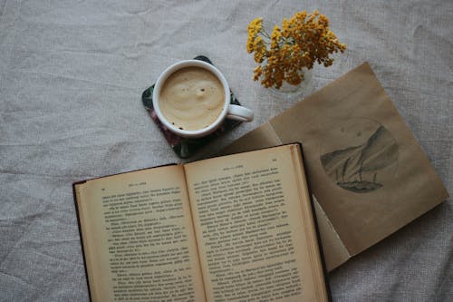 Free Overhead Shot of a Cup of Coffee Beside a Book Stock Photo