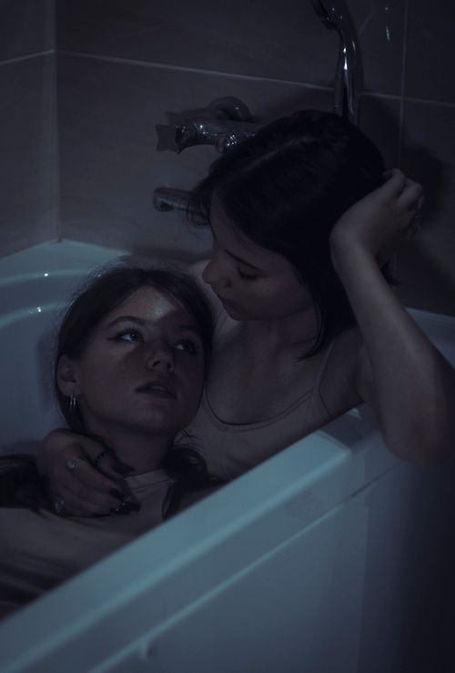Free Two women sharing a tender and intimate moment in a bathtub. Stock Photo