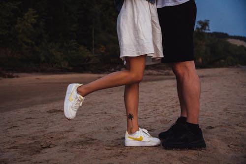Free Photo of a Black and White Sneakers on the Sand Stock Photo