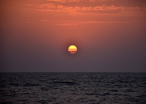 Free Stunning sunset with a vibrant sky reflecting over a serene ocean. Stock Photo