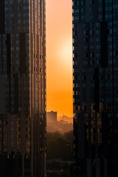 Moscow city skyline with skyscrapers framing a vibrant sunset, creating a stunning urban silhouette.