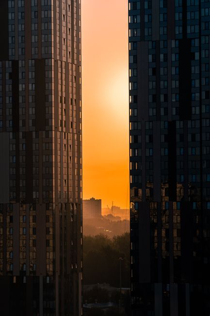 Moscow city skyline with skyscrapers framing a vibrant sunset, creating a stunning urban silhouette.