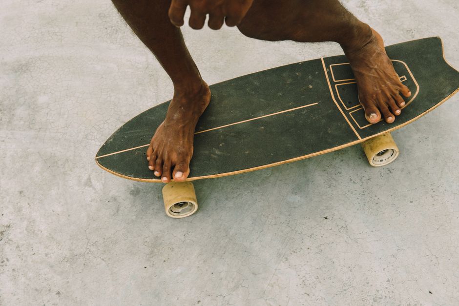 Close-up of a barefoot skateboarder gliding on a concrete pavement, showcasing balance and skill.