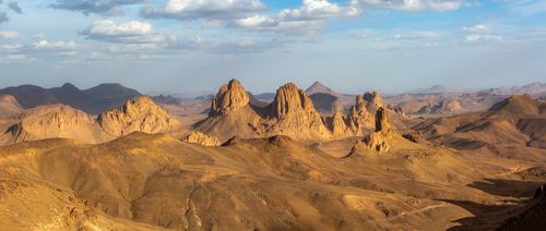Free Panoramic view of rocky formations in the Sahara desert under a clear blue sky. Stock Photo