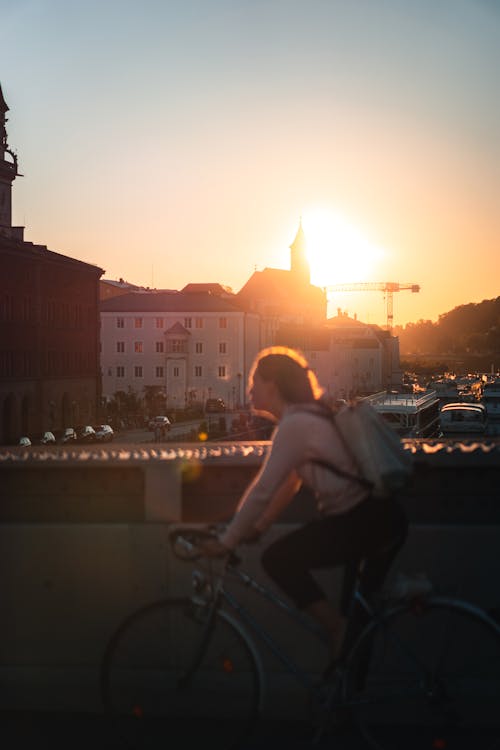 Free Woman Riding on a Bicycle During Sunset Stock Photo