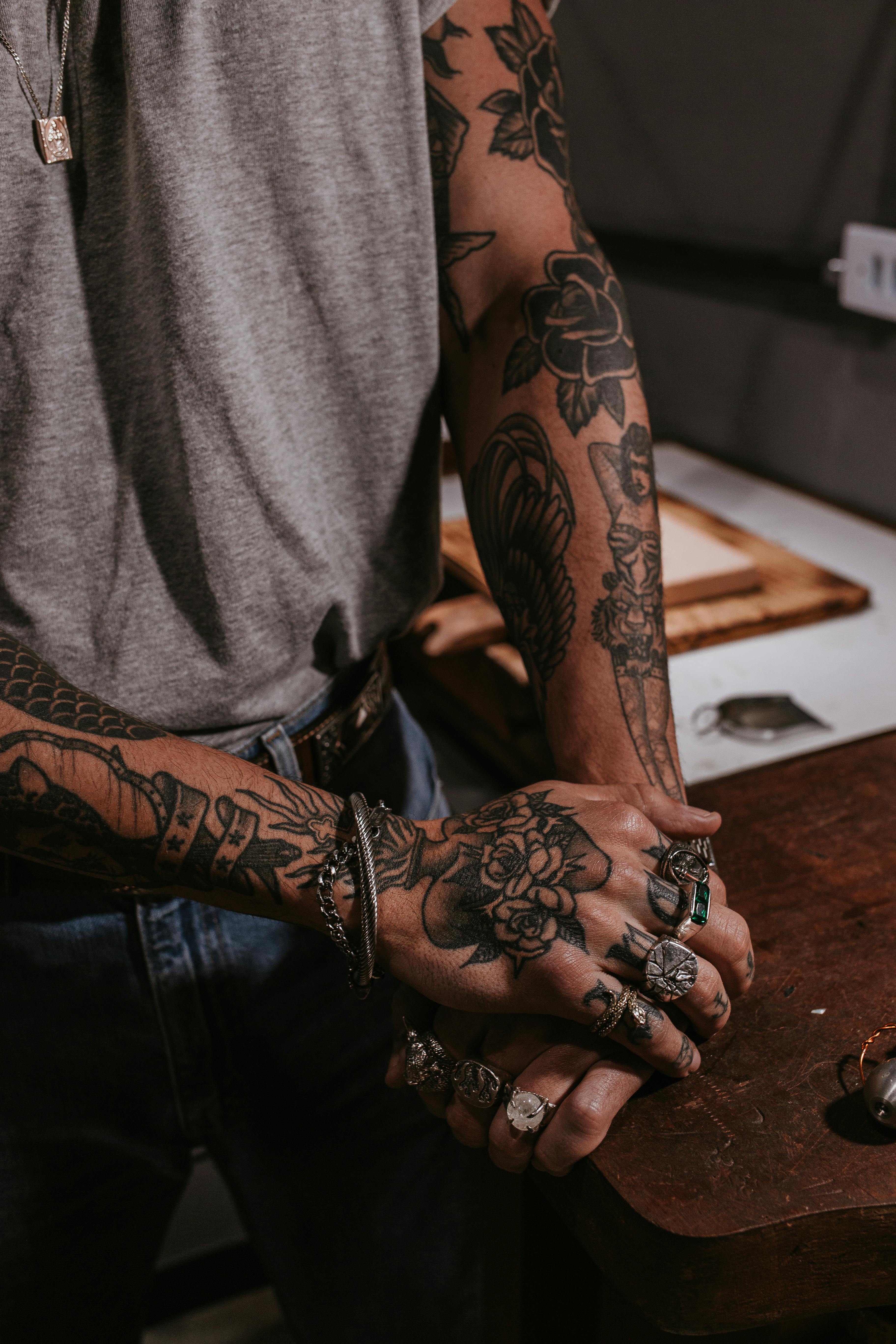 a tattooed person wearing rings