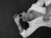 A Man Lying on the Ground while Wearing Sunglasses