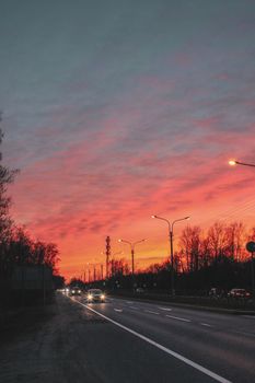 Stunning sunset casting a warm glow over an expressway with moving cars.
