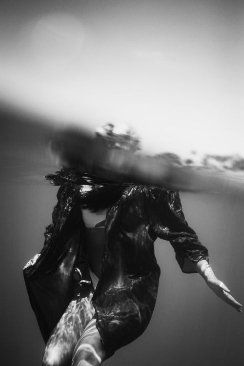 Free Black and white photo of a woman in flowing clothing underwater. Stock Photo