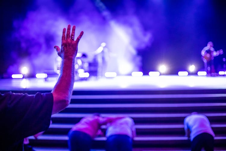 A Person Raising The Hand In Front Of The Stage