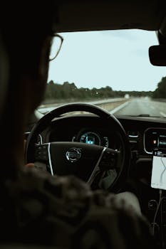 Experience a tranquil drive in a Volvo as the road unfolds ahead. Ideal for travel and lifestyle themes.