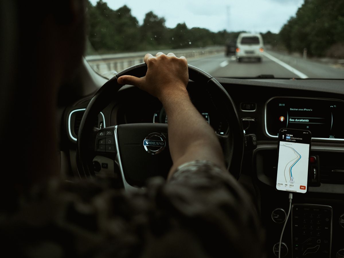 A driver using an in-car digital navigation and policy app on a smartphone