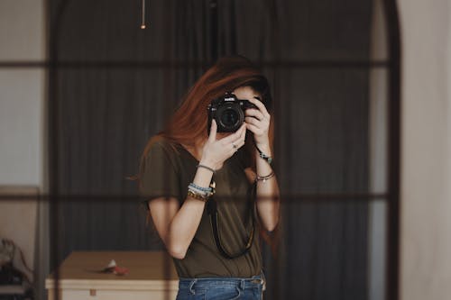 A Woman Taking Photo of Herself in the Mirror Using a Dslr Camera