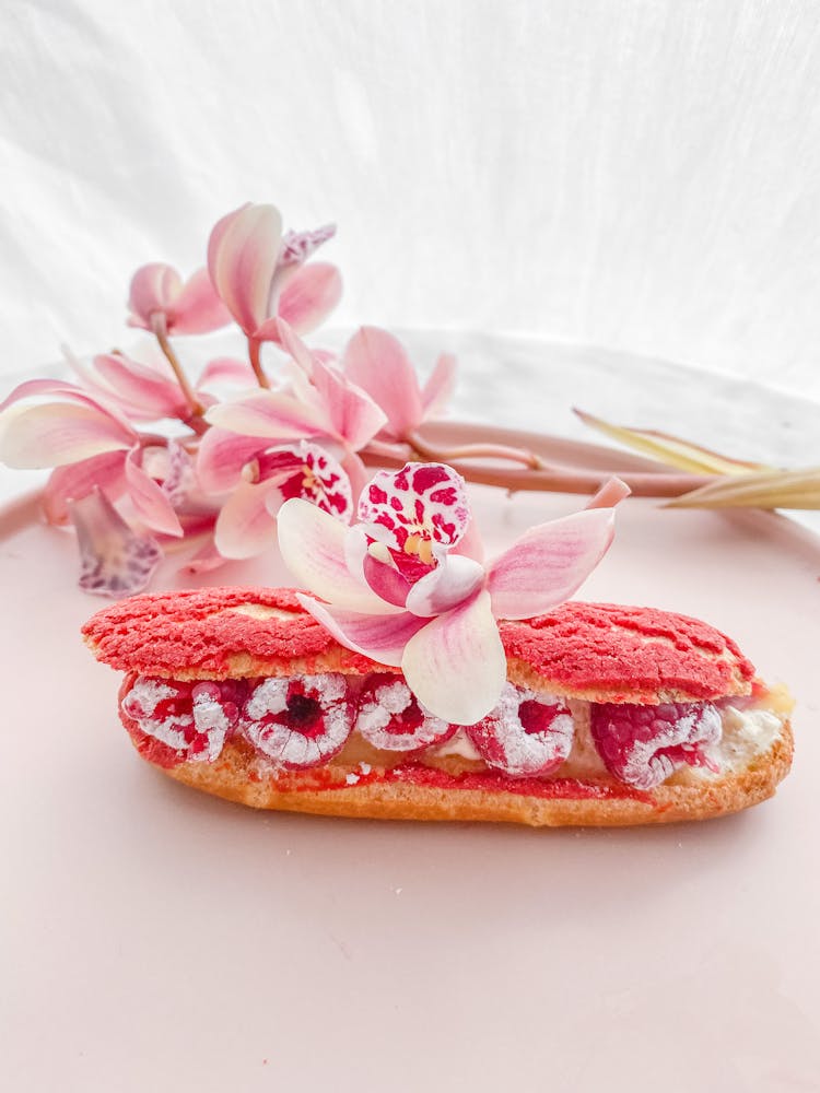 Pink Orchid Flower On A Bun With Red Berries