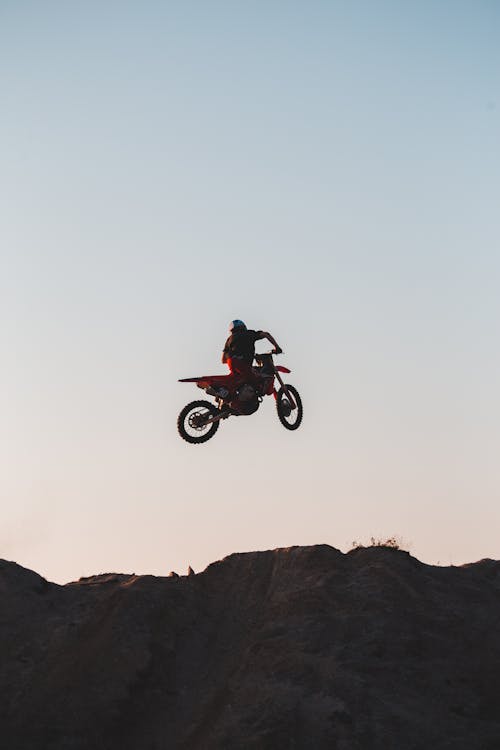 Free A Person on a Motorcycle above a Hill Stock Photo