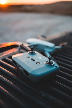 Close-up of a drone controller placed on an outdoor surface during sunset, showcasing modern technology.