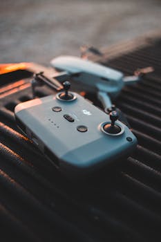 Close-up of a drone controller and drone in a dramatic sunset setting.