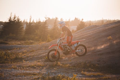 Free A Person Standing on a Running Dirt Bike Stock Photo