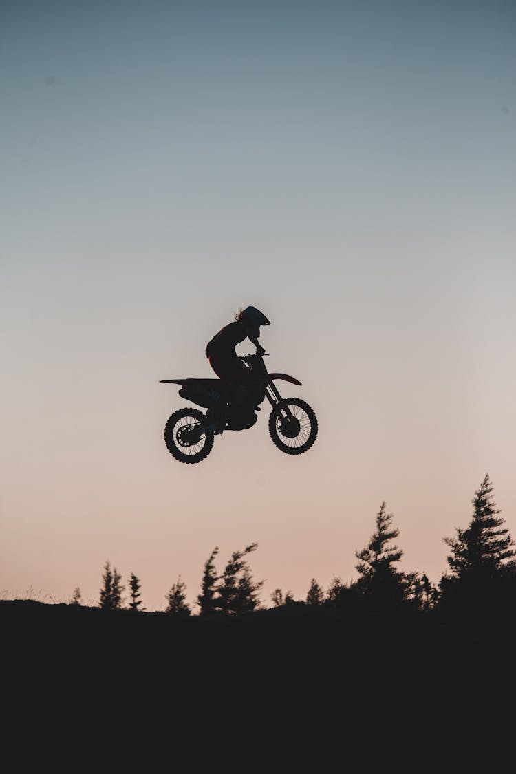 Silhouette Of A Man Riding Motocross Dirt Bike On Mid Air