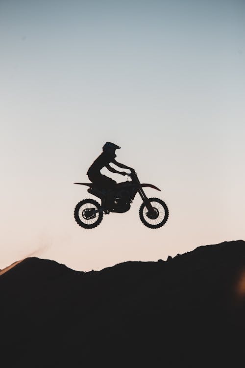 Silhouette of Person Riding Dirt Bike on Air