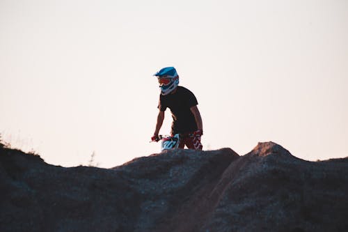 A Man with a Helmet Riding a Dirt Bike