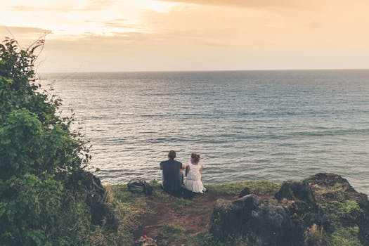 Man and Woman Sitting Near Body of Water