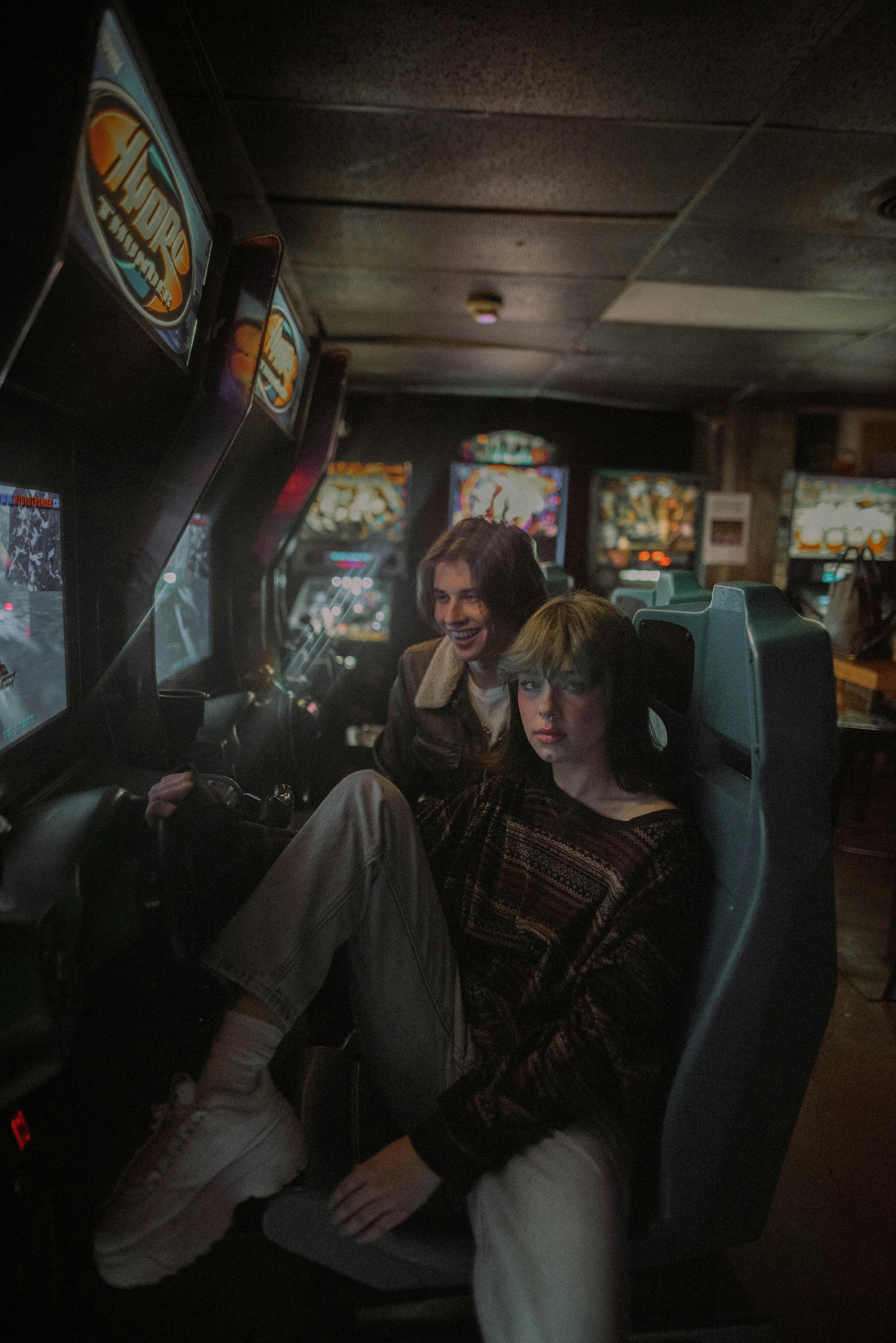 a couple sitting at the arcade games seats