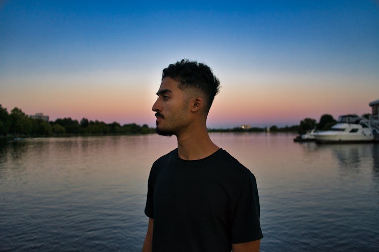 Man In Black Shirt Near Body Of Water