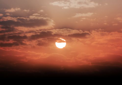 Beautiful golden hour sunset with orange sky and clouds, creating a dramatic view.