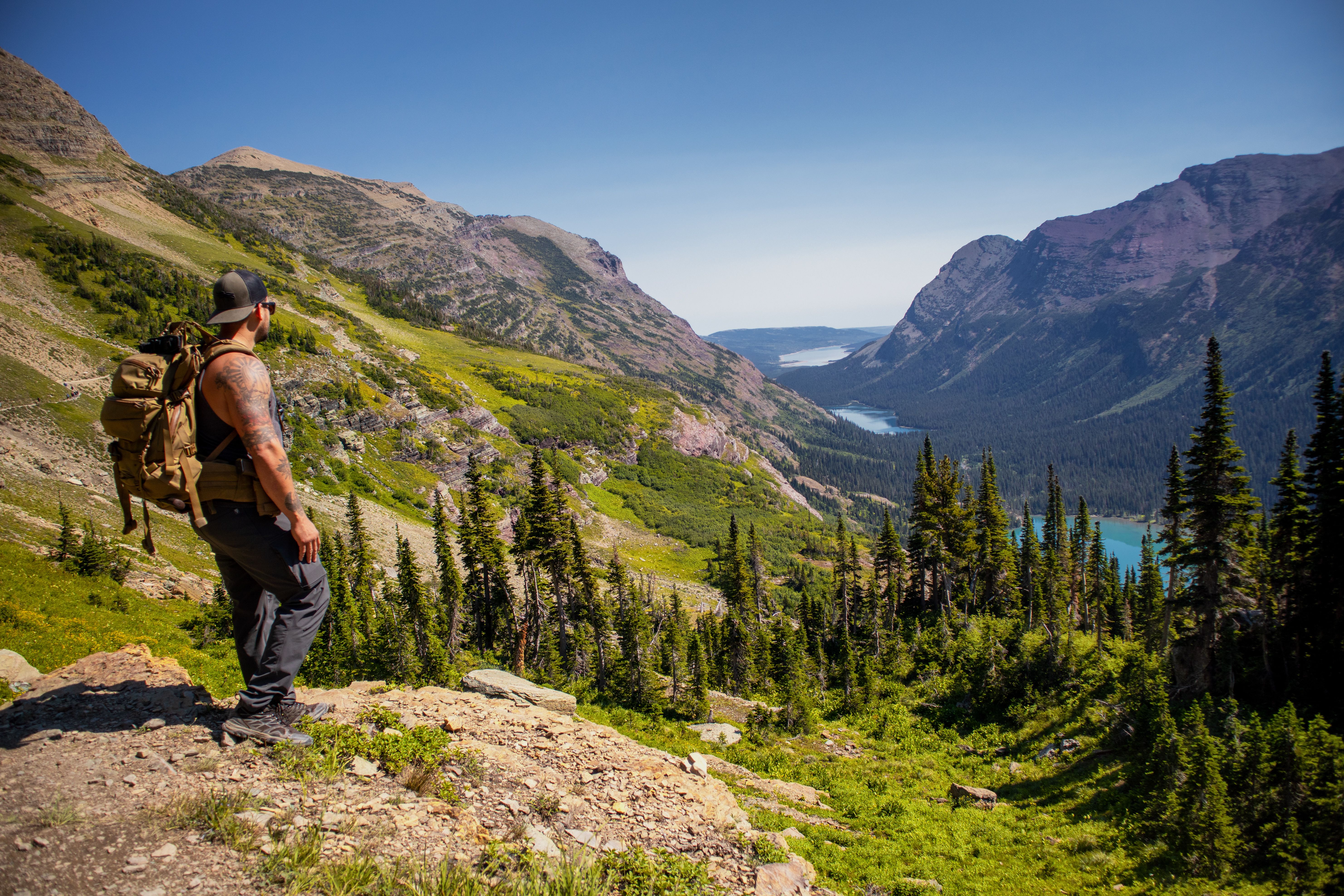 Hiker with backpack on a mountain trail at daybreak